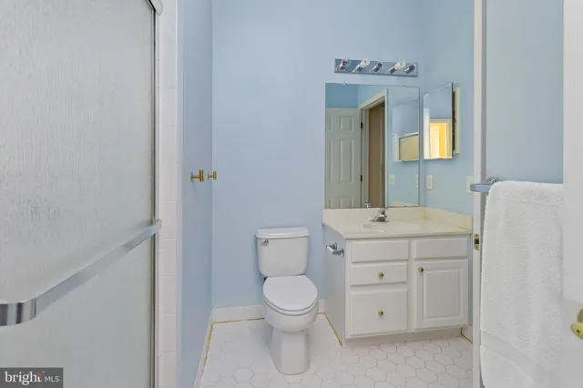 a bathroom with a toilet sink vanity and mirror