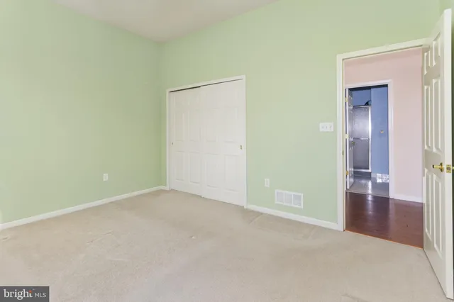 an empty room with closet and mirror