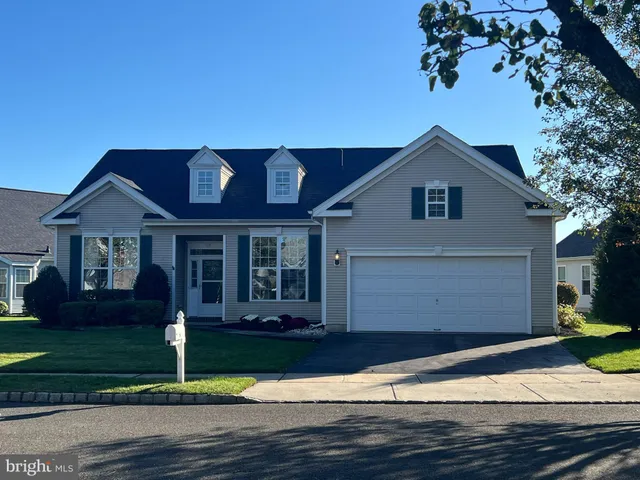 a front view of a house with a garden and yard
