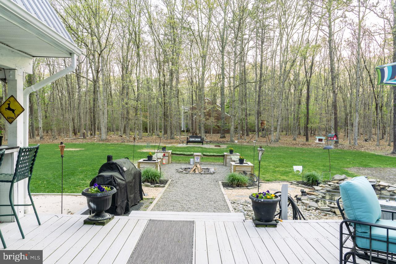 17 Red Oak Drive Tabernacle, NJ 08088 - Photo 36 of 45 a view of a deck with table and chairs potted plants and a palm tree