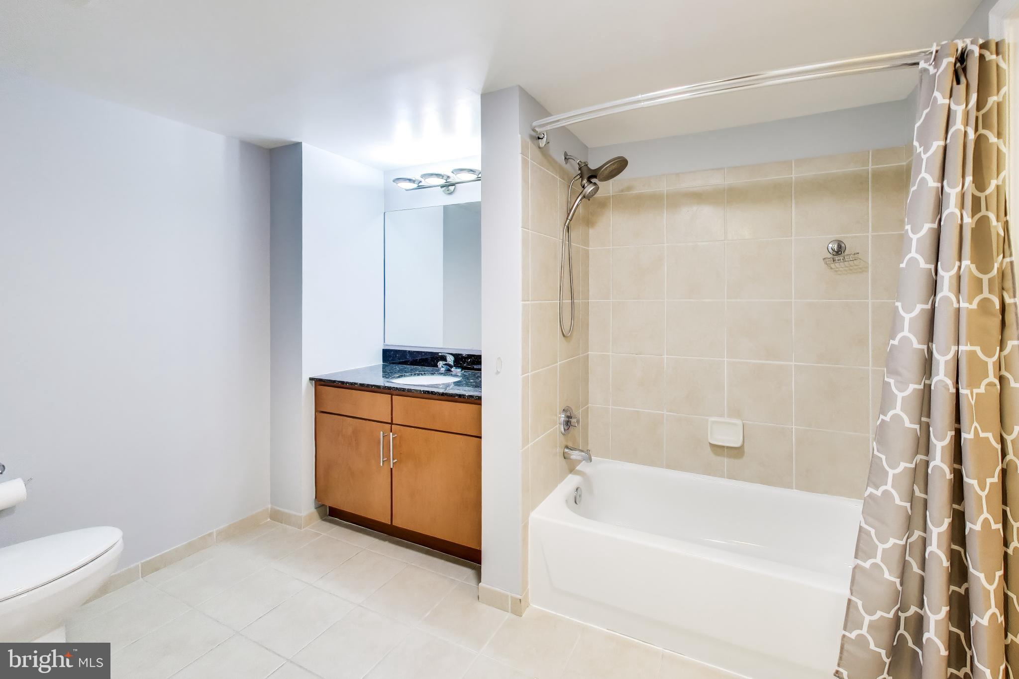 915 E Street Northwest, Unit 414 Washington, DC 20004 - Photo 17 of 35 a bathroom with a granite countertop sink toilet and shower