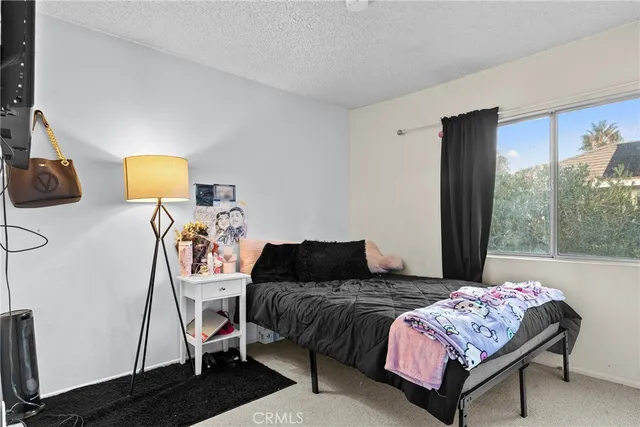 a bedroom with a bed and a large window