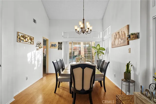 a view of a dining room with furniture a chandelier and wooden floor