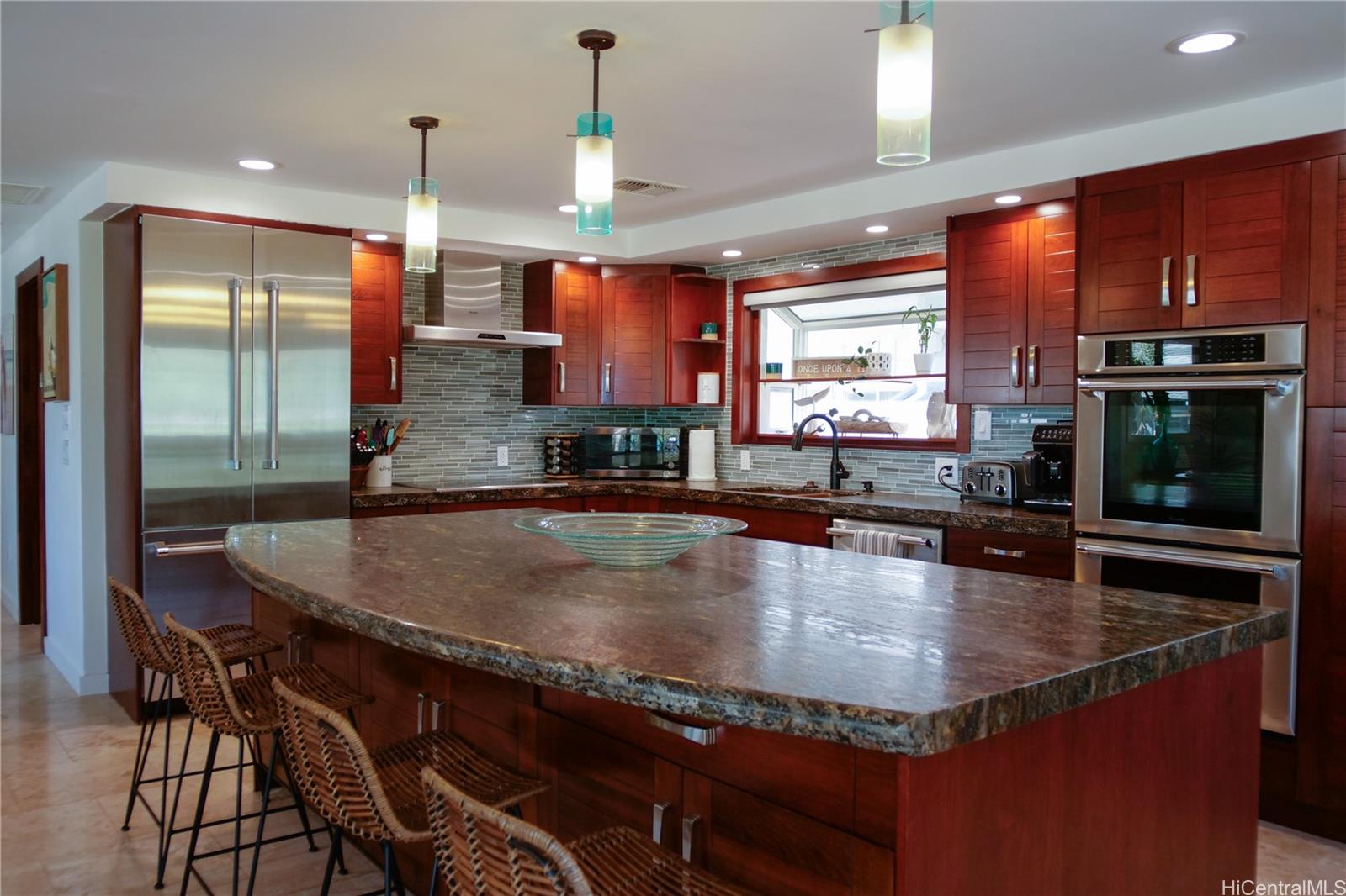 a dining table with chairs and kitchen view