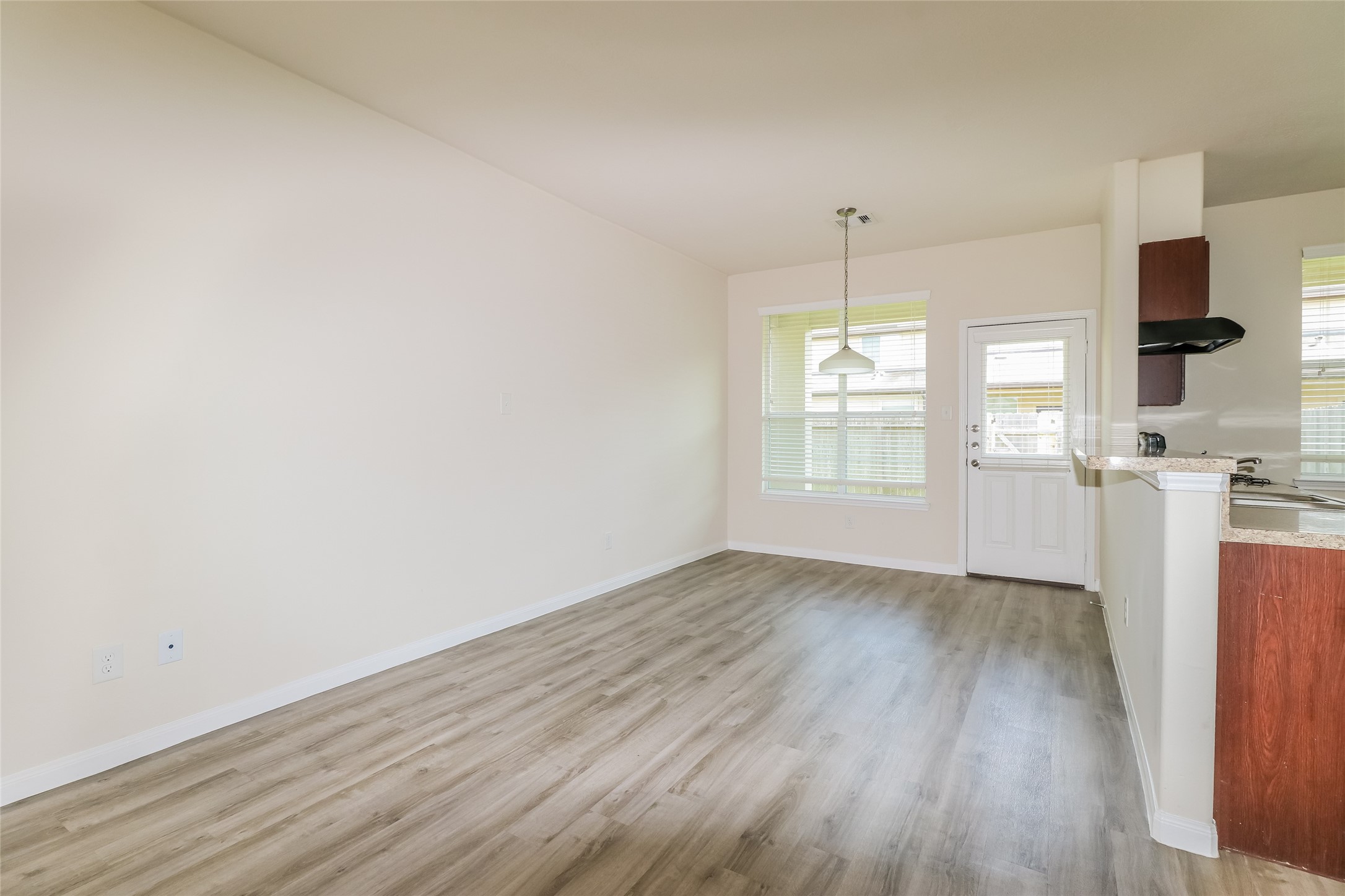 9707 Elia Court Houston, TX 77044 - Photo 10 of 17 an empty room with wooden floor and windows