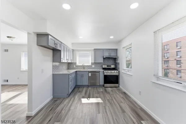 a kitchen with granite countertop a stove top oven and cabinets