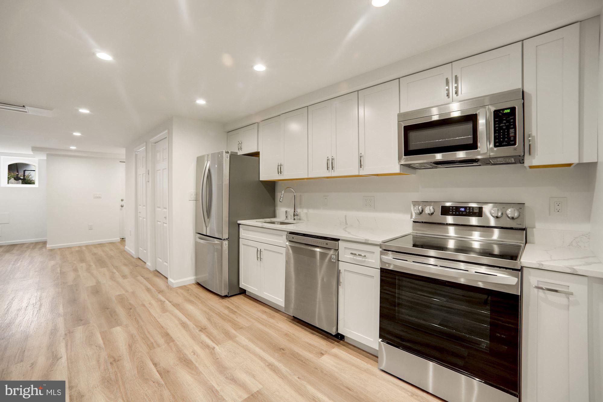 1215 S Street Northwest, Unit B Washington, DC 20009 - Photo 11 of 18 a kitchen with stainless steel appliances granite countertop a stove a sink and a microwave