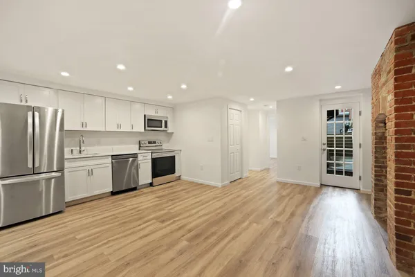 a kitchen with stainless steel appliances a refrigerator and wooden floor
