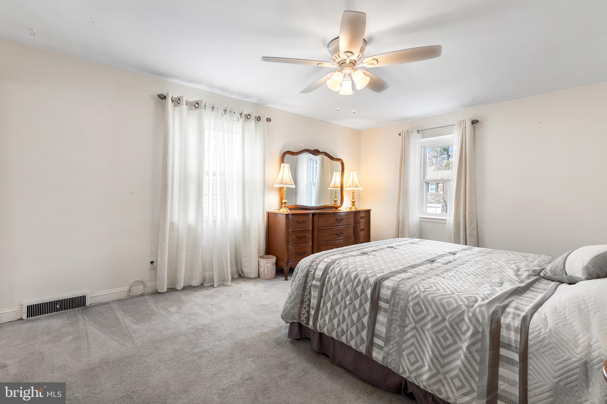325 Wyndmoor Road Springfield, PA 19064 - Photo 20 of 45 a spacious bedroom with a bed a dresser and a chandelier
