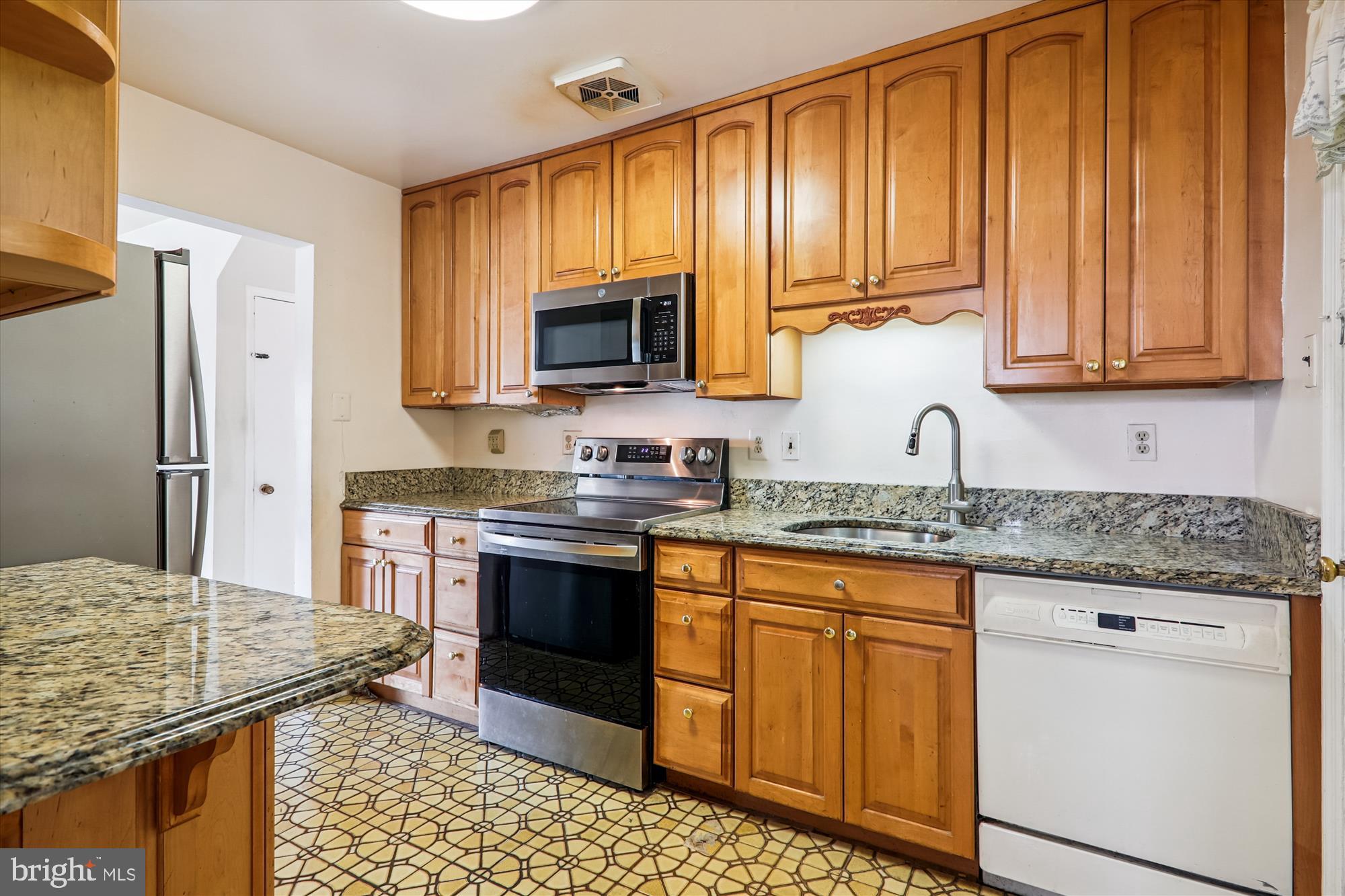 9507 Adelphi Road Silver Spring, MD 20903 - Photo 12 of 41 a kitchen with stainless steel appliances granite countertop a stove a sink dishwasher and a refrigerator