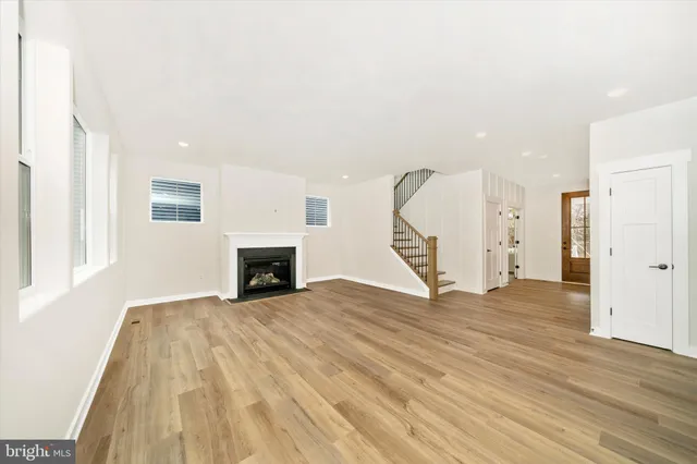 a large kitchen with stainless steel appliances a stove a sink a refrigerator and white cabinets