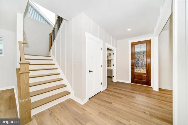 a view of a hallway with wooden floor and entryway