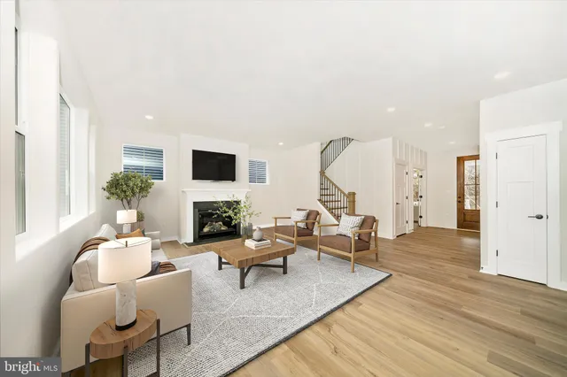 a living room with fireplace furniture and a large window
