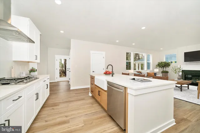 a large kitchen with stainless steel appliances lots of counter space and wooden floor