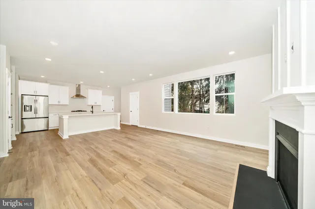 a view of a kitchen with wooden floor and windows