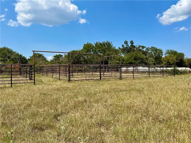 a view of swimming pool with seating area and small garden