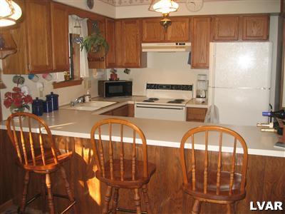 2303 Sage Rd Mount Long Pond, PA 18334 - Photo 3 of 15 a kitchen with stainless steel appliances granite countertop a refrigerator a stove a sink and a microwave