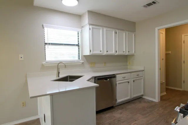 a kitchen with stainless steel appliances white cabinets and a stove top oven