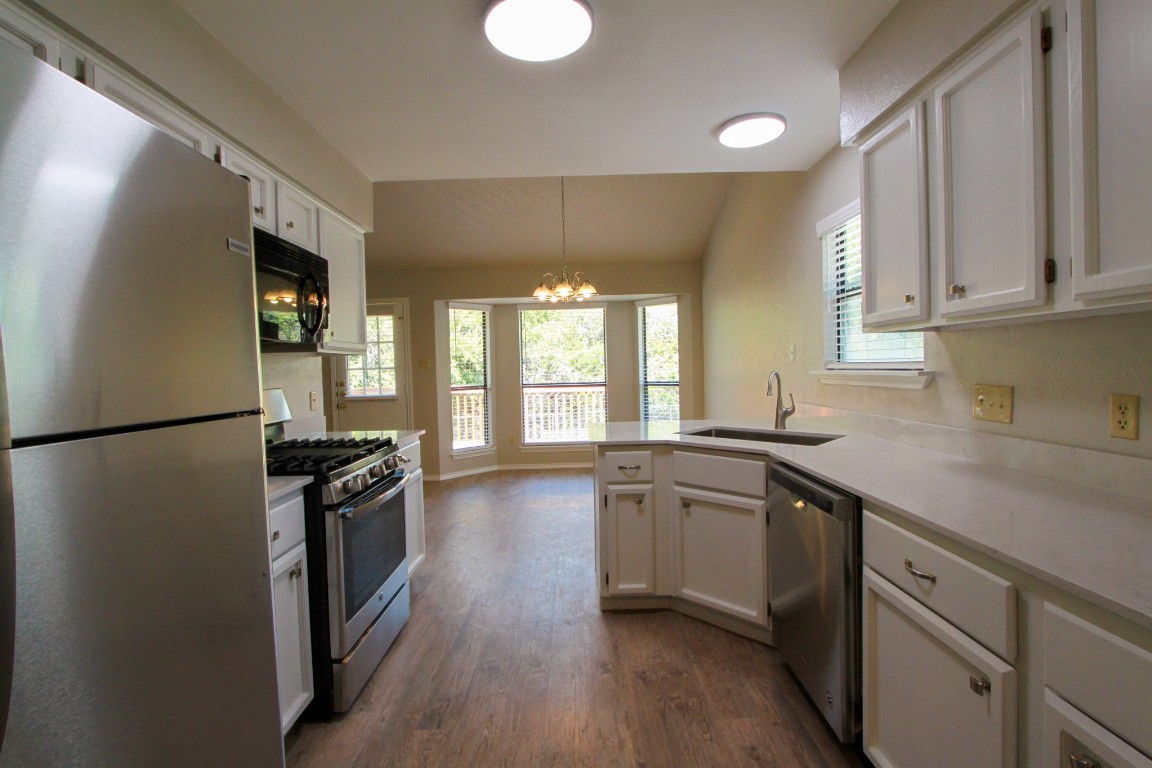 605 Timber Trail Cedar Park, TX 78613 - Photo 15 of 36 a kitchen with granite countertop a refrigerator stove top oven and sink