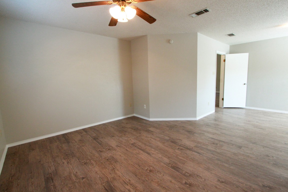 605 Timber Trail Cedar Park, TX 78613 - Photo 19 of 36 an empty room with wooden floor and windows