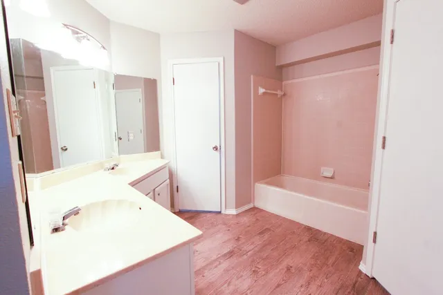 a bathroom with a tub sink and mirror