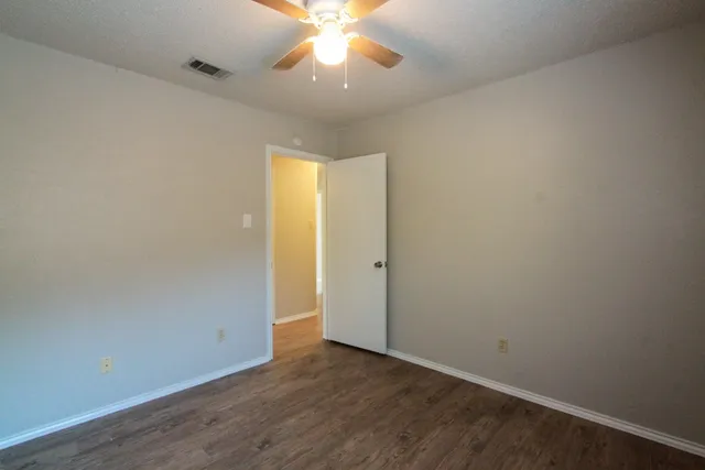 an empty room with a window and a ceiling fan