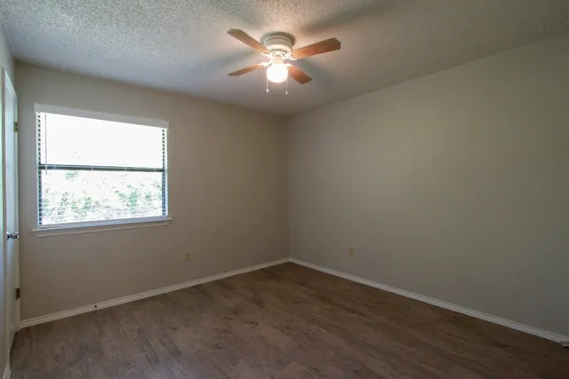 an empty room with closet and a chandelier fan