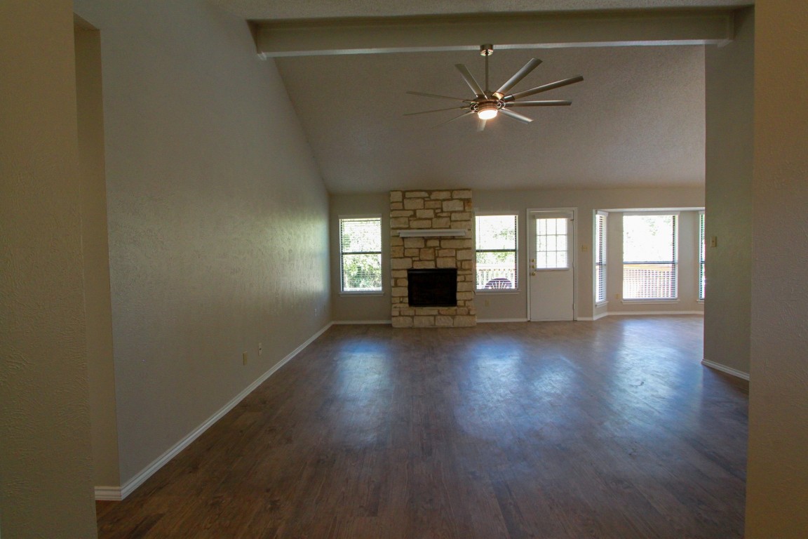 605 Timber Trail Cedar Park, TX 78613 - Photo 6 of 36 an empty room with wooden floor fireplace and windows