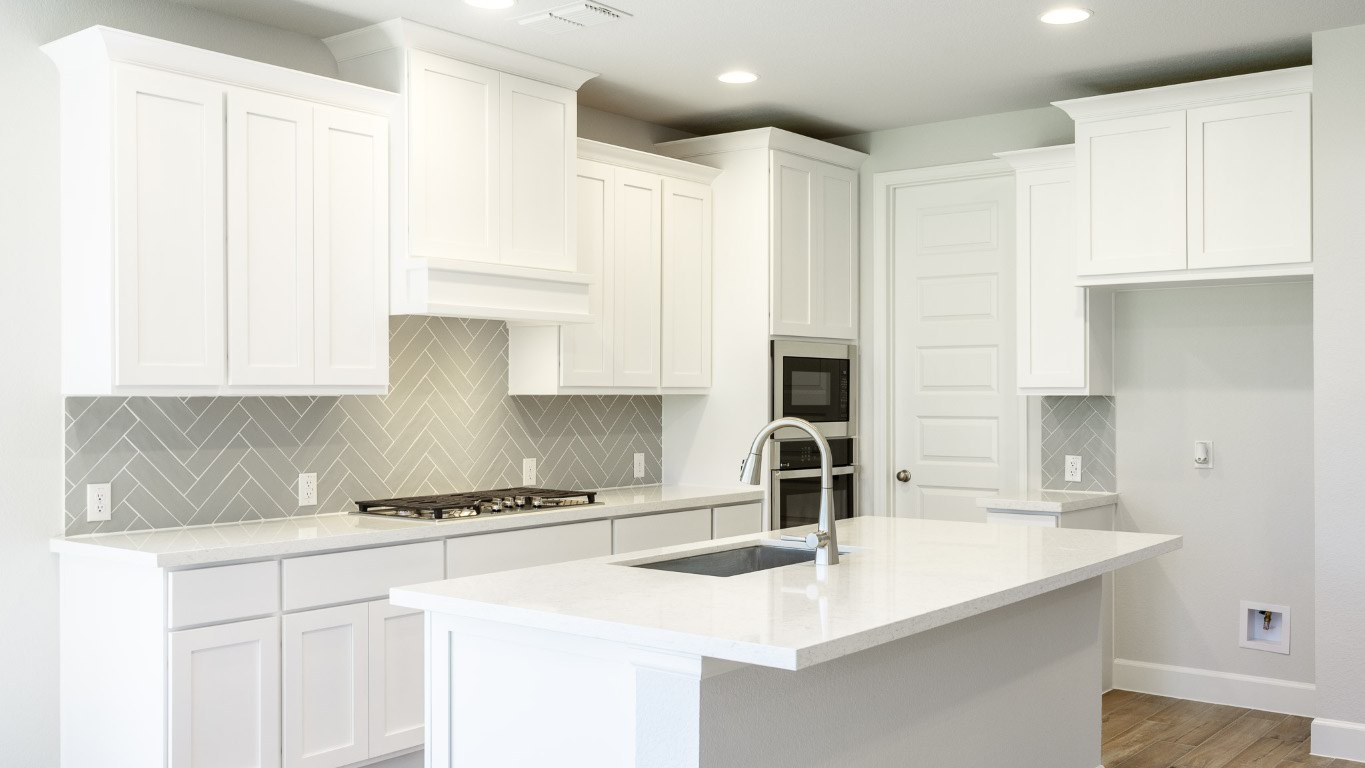 213 Adali Avenue Georgetown, TX 78633 - Photo 7 of 16 Kitchen featuring tasteful backsplash, light stone countertops, a center island with sink, white cabinetry, and recessed lighting