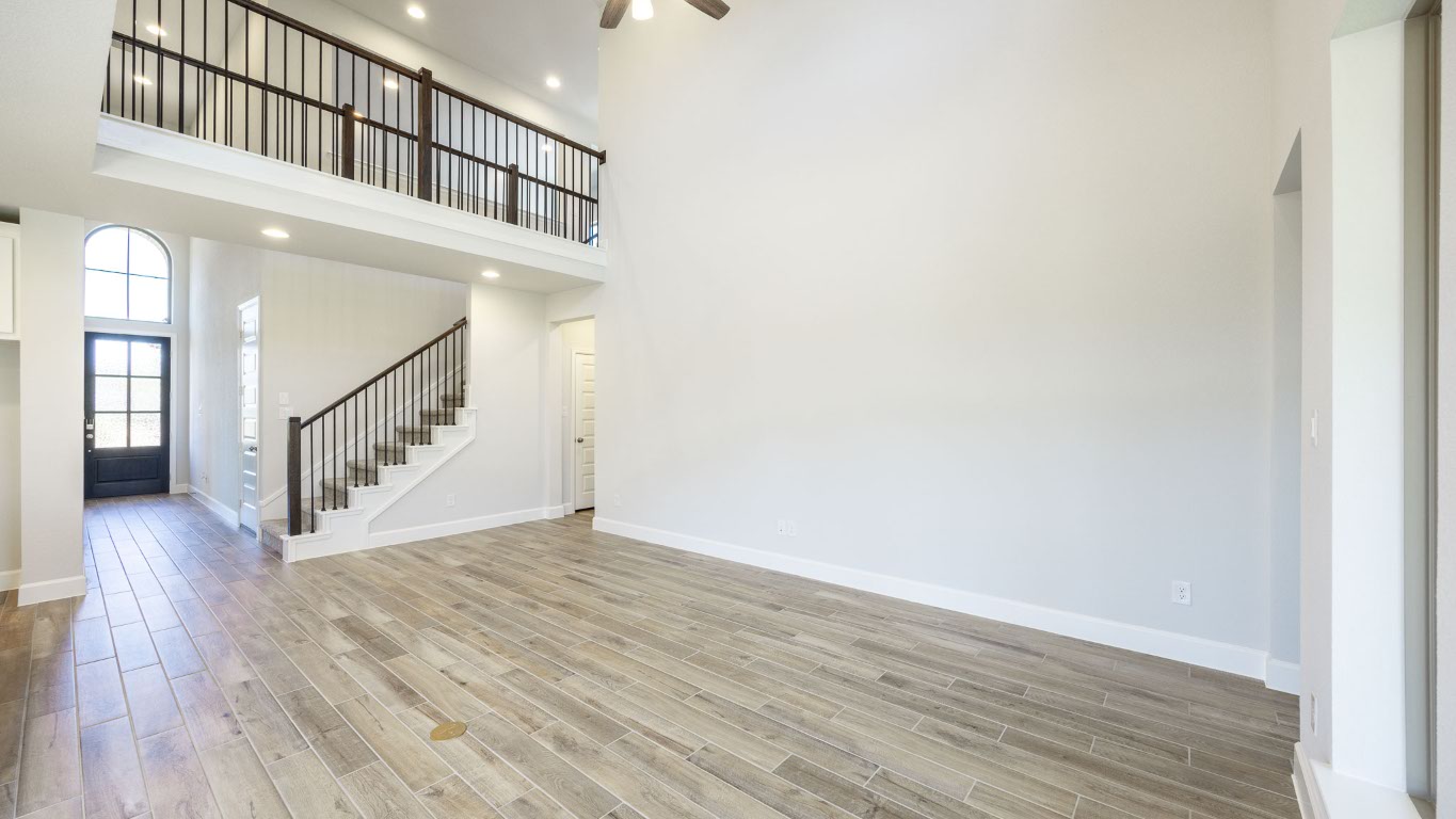 213 Adali Avenue Georgetown, TX 78633 - Photo 8 of 16 Unfurnished living room featuring a high ceiling, stairway, wood finished floors, and recessed lighting