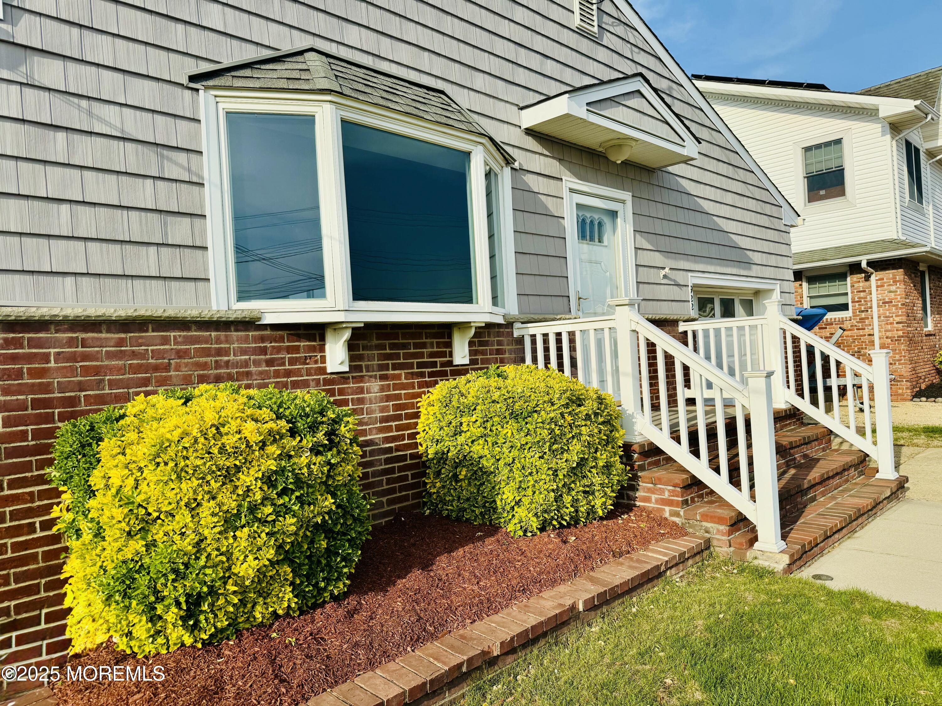 a view of a house with a small yard and wooden floor and fence