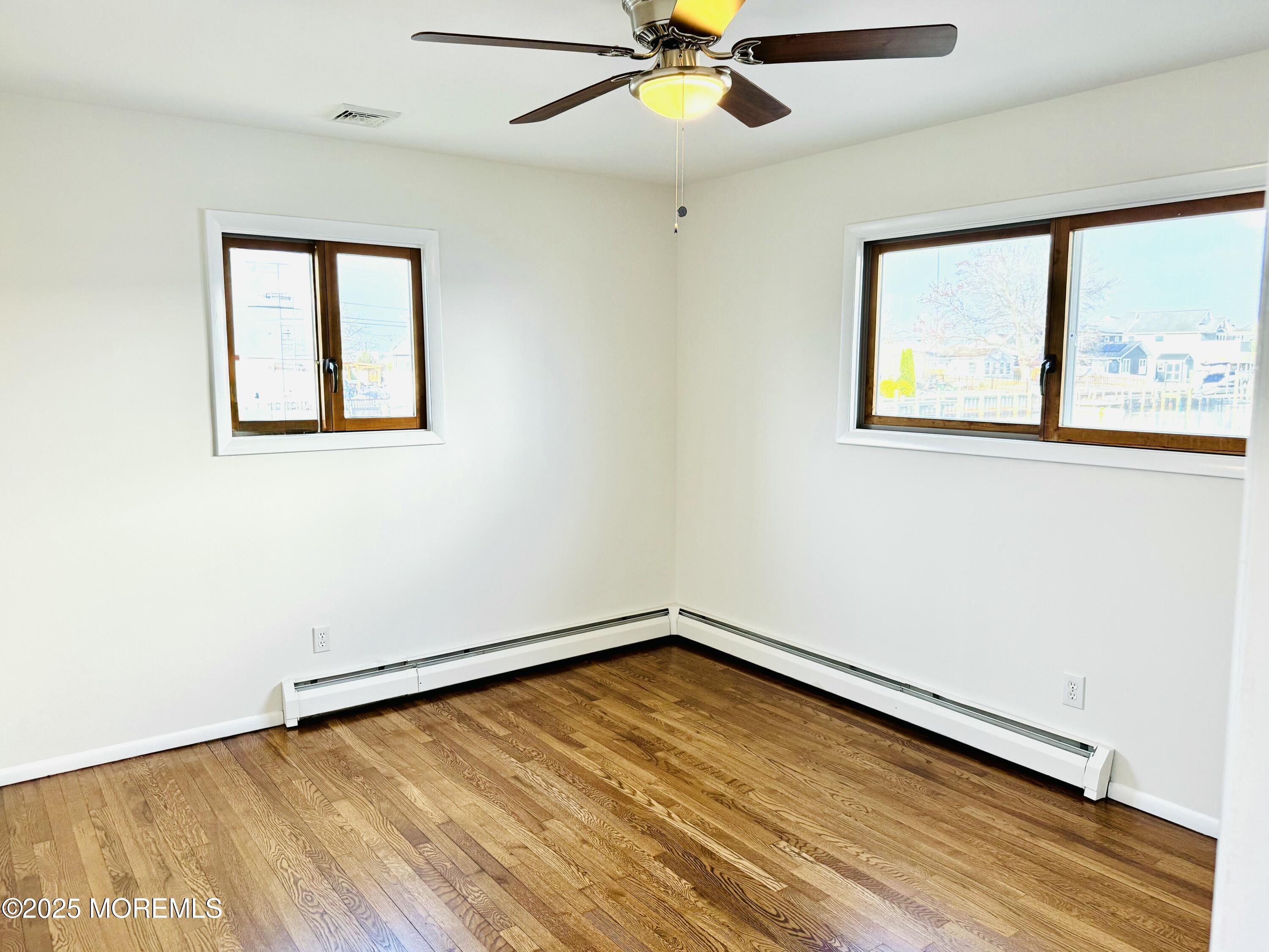 922 Capstan Drive Forked River, NJ 08731 - Photo 11 of 26 wooden floor in an empty room with a window