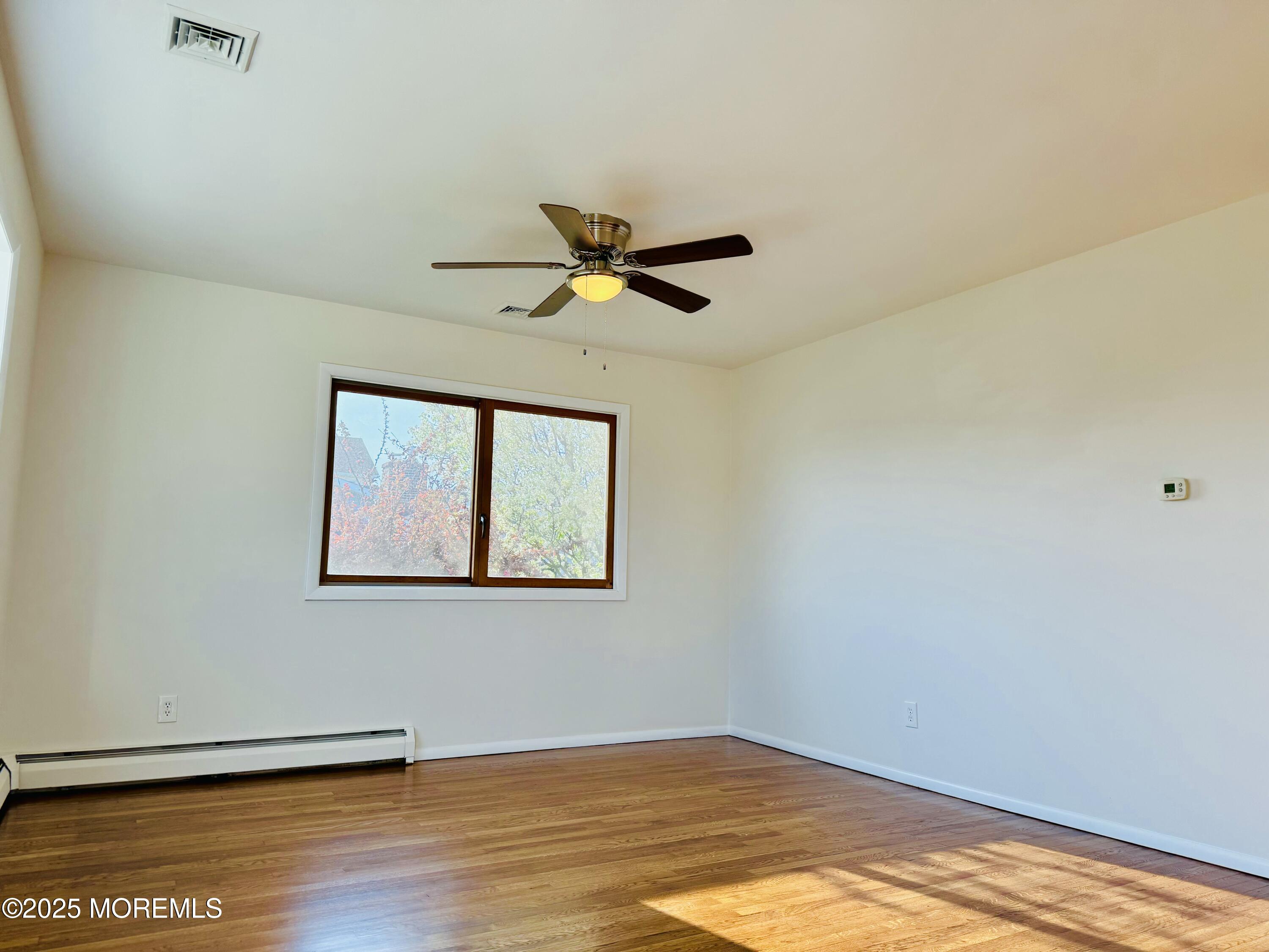 922 Capstan Drive Forked River, NJ 08731 - Photo 7 of 26 a view of room with wooden floor and a ceiling fan