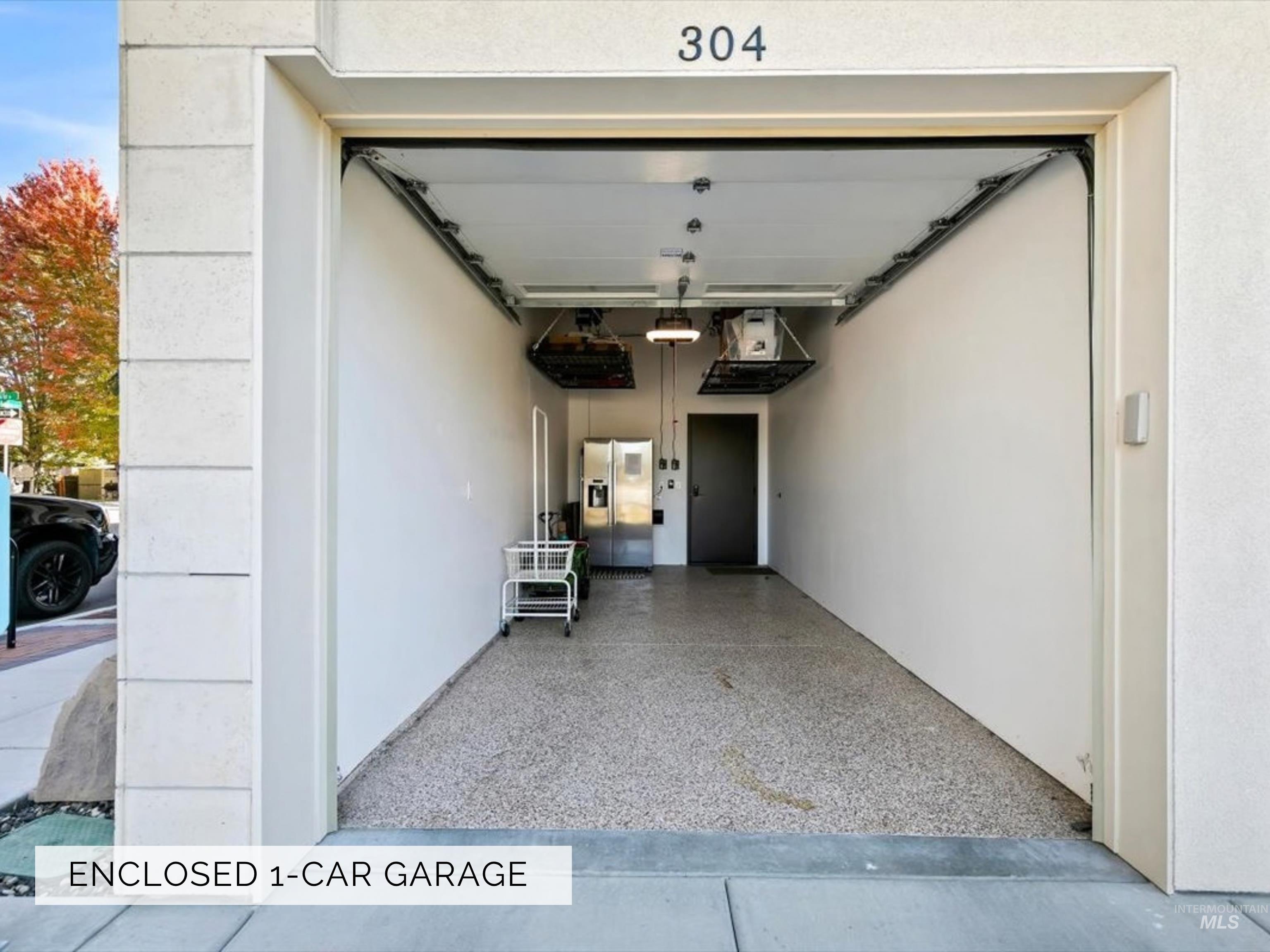 79 East Aikens Road, Unit 304 Eagle, ID 83616 - Photo 34 of 42 Enclosed 1-car garage with an epoxy-finished floor, overhead storage racks, and a side-entry door