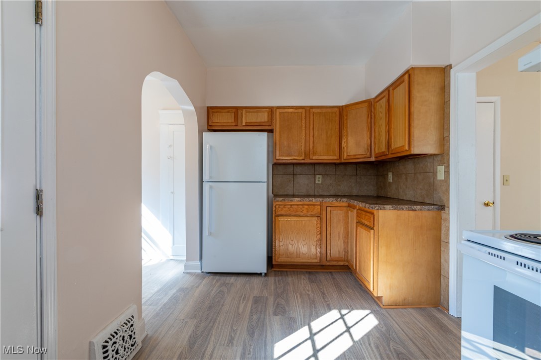 14426 Superior Road Cleveland, OH 44118 - Photo 18 of 50 Kitchen with wood-type flooring, backsplash, and white appliances