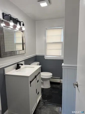a bathroom with a toilet sink and mirror