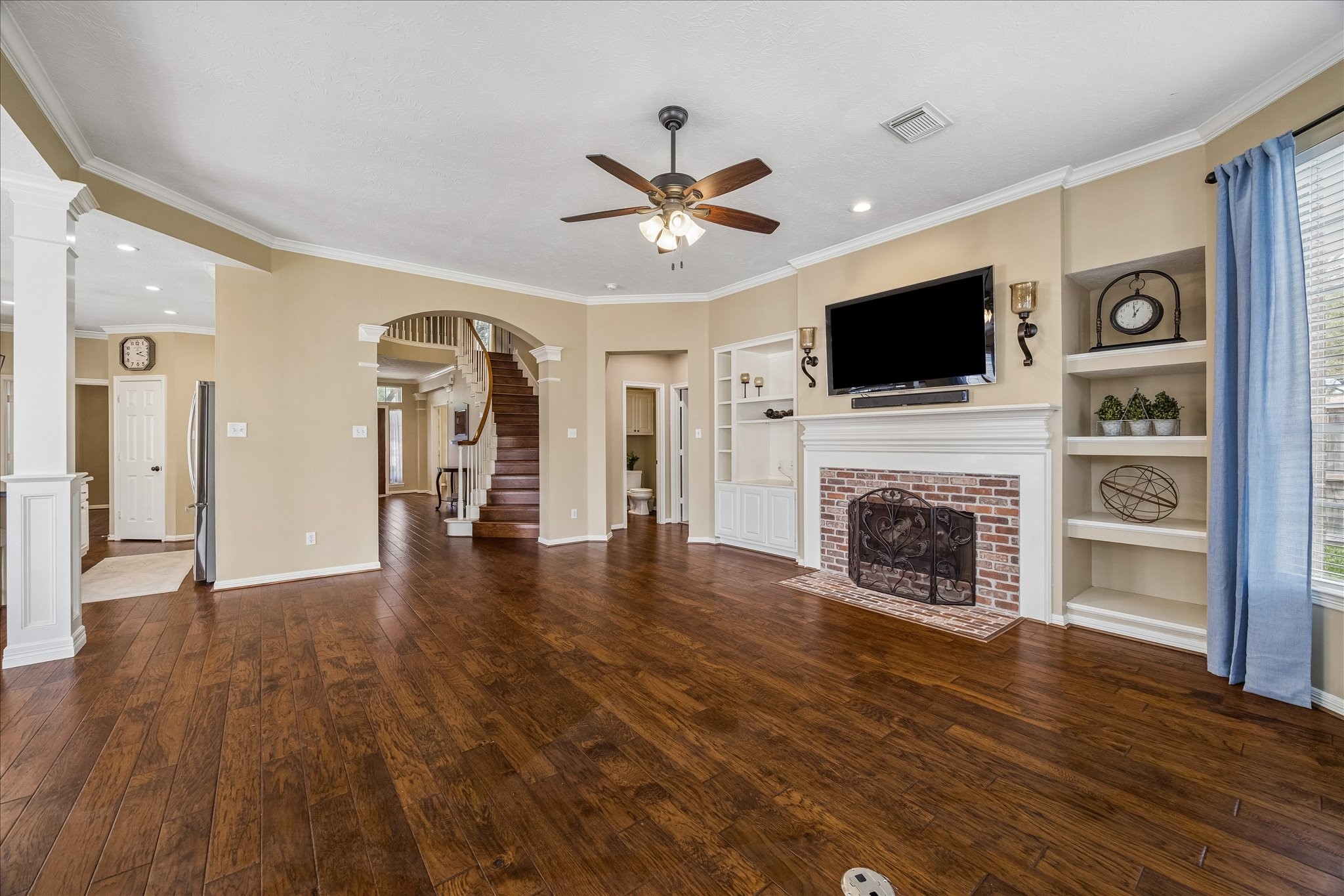 5310 Summerland Ridge Court Houston, TX 77041 - Photo 12 of 46 a view of a livingroom with a fireplace a ceiling fan and a kitchen view