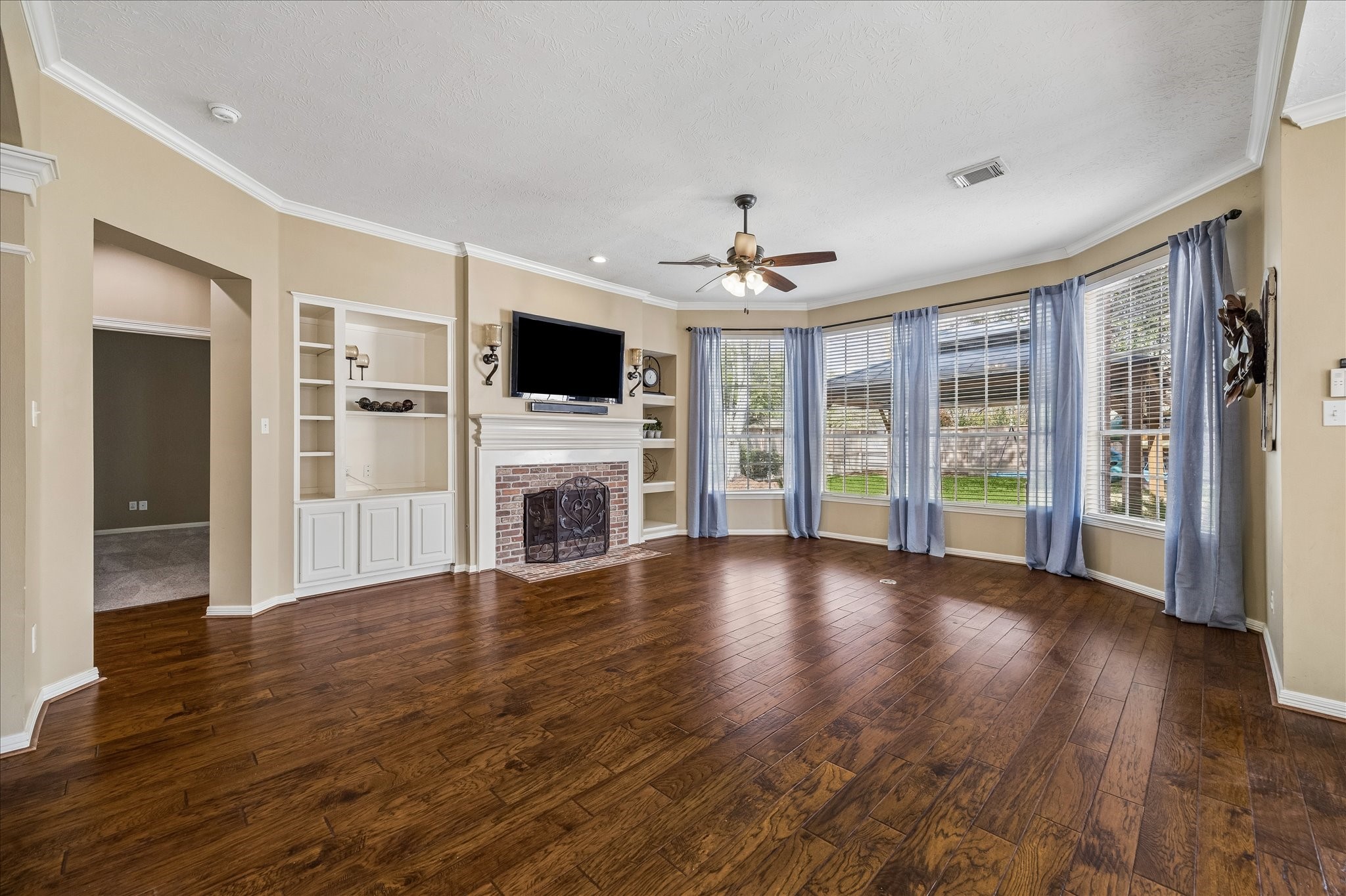 5310 Summerland Ridge Court Houston, TX 77041 - Photo 19 of 46 a view of a livingroom with wooden floor a flat screen tv and a fireplace