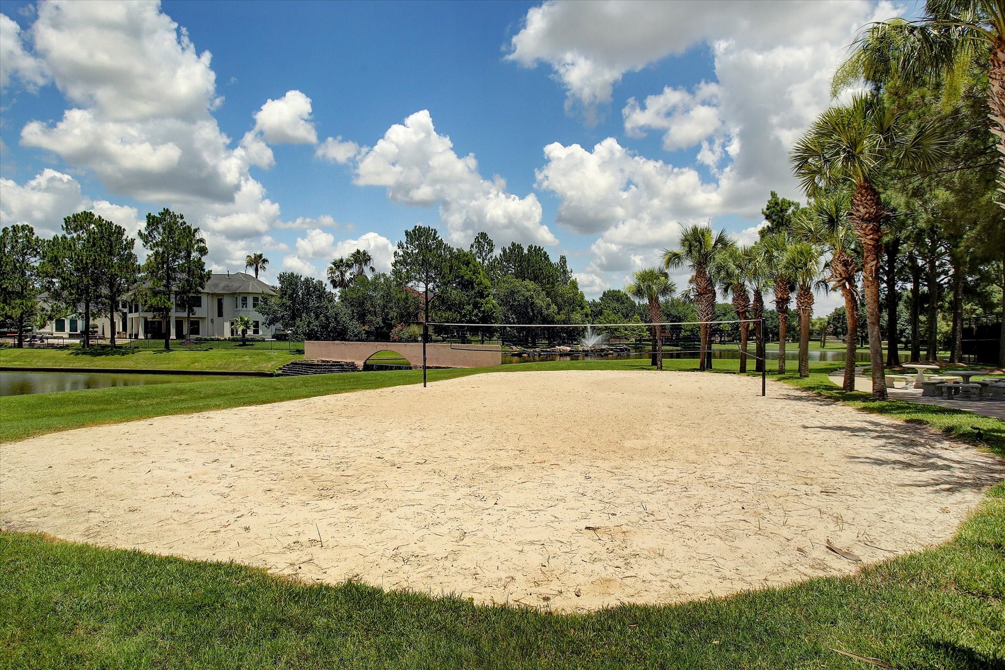 5310 Summerland Ridge Court Houston, TX 77041 - Photo 45 of 46 Lakes on Eldridge offers sand volleyball court set in a lush, landscaped area with palm trees and a pond nearby. Offering a scenic and recreational community environment.