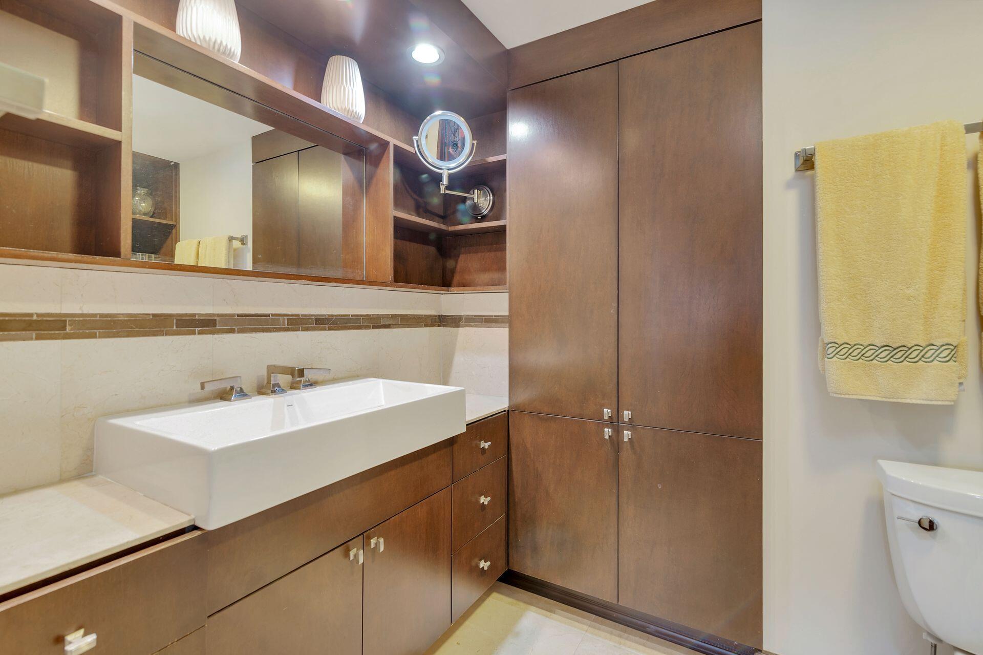 170 North Ocean Boulevard, Unit 409 Palm Beach, FL 33480 - Photo 12 of 34 a bathroom with a sink a toilet and mirror