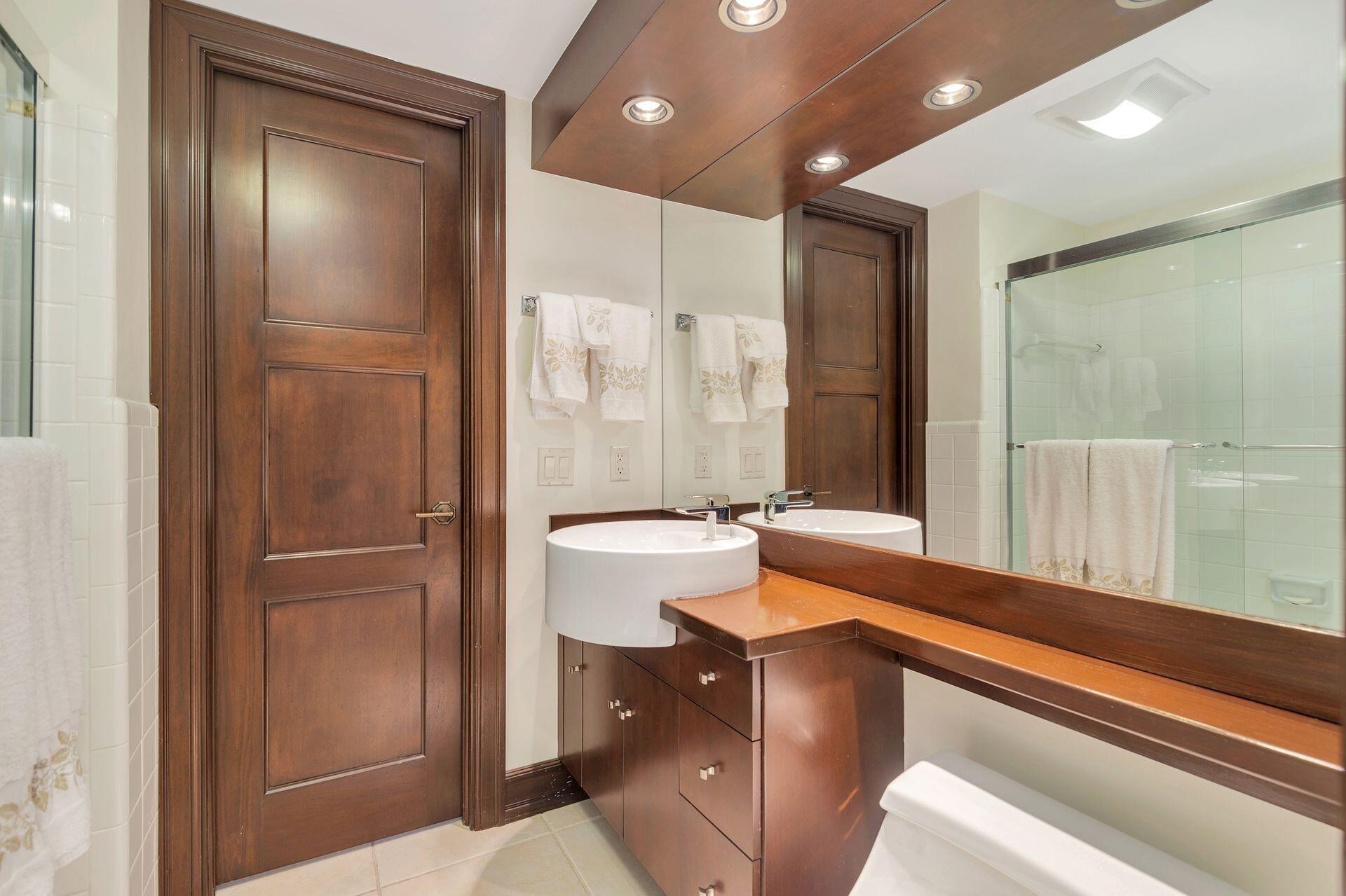 170 North Ocean Boulevard, Unit 409 Palm Beach, FL 33480 - Photo 16 of 34 a bathroom with a tub and a shower