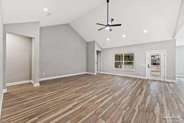 a view of empty room with wooden floor and window