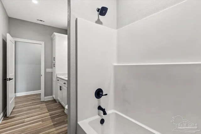 a bathroom with a tub and glass door