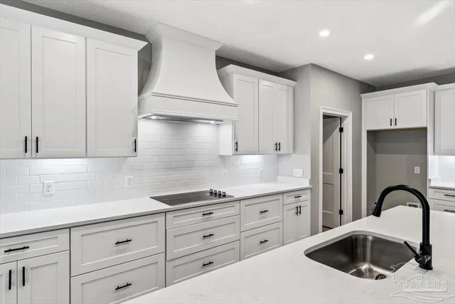 a kitchen with granite countertop a sink stainless steel appliances and cabinets