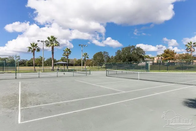 a view of a swimming pool with a table and chairs under an umbrella