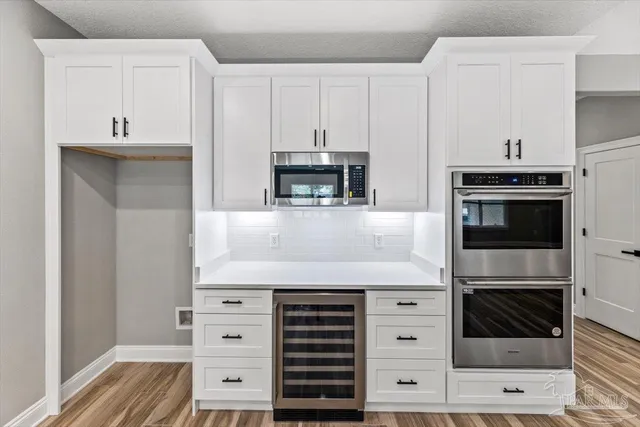 a kitchen with cabinets stainless steel appliances and a counter space