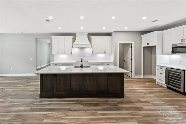 a view of kitchen with sink refrigerator and wooden floor