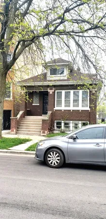 a view of a house with a cars park side of a road
