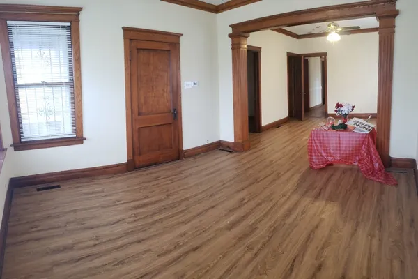 a hallway with wooden floor and closet
