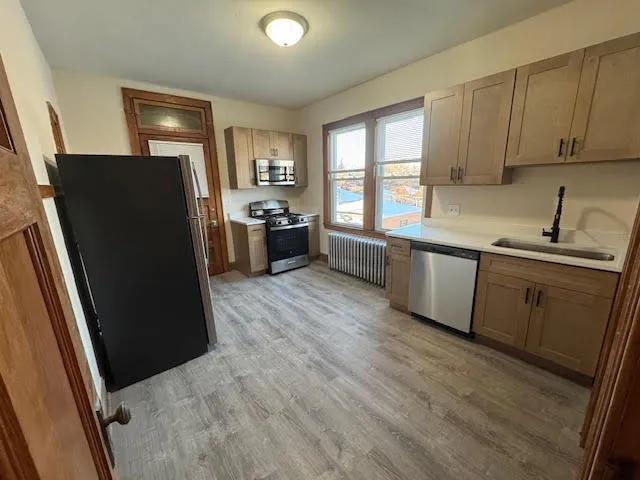 a kitchen with granite countertop a refrigerator stove top oven and sink